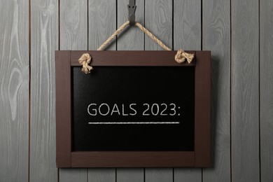 Image of Blackboard with phrase GOALS 2023 on hanging on grey wooden background