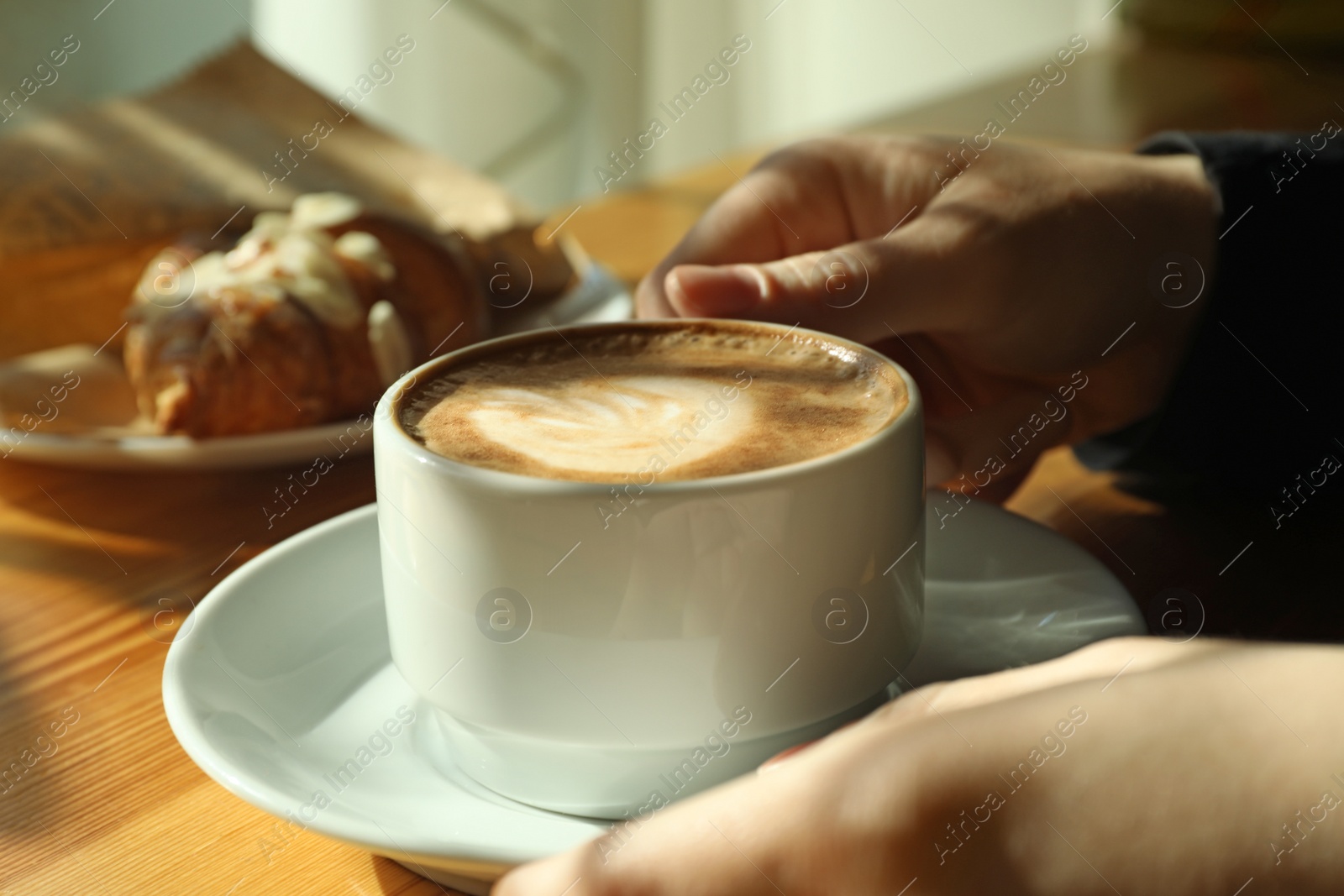 Photo of Woman with cup of fresh aromatic coffee at table in cafe