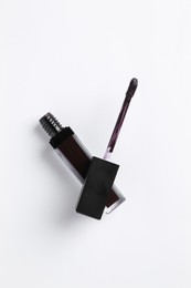 Photo of Purple lip gloss and applicator on white background, top view
