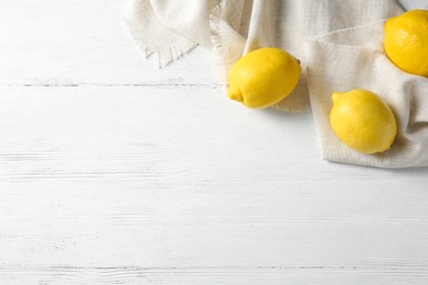 Flat lay composition with ripe lemons on wooden background