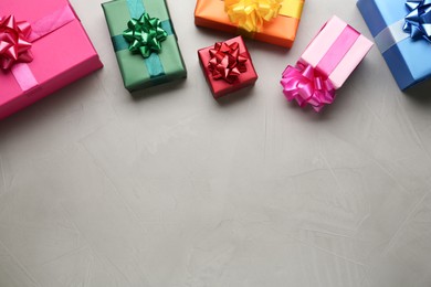 Photo of Many colorful gift boxes on light grey table, flat lay. Space for text