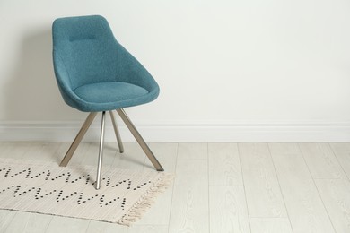 Photo of Stylish dark green chair near white wall indoors. Space for text