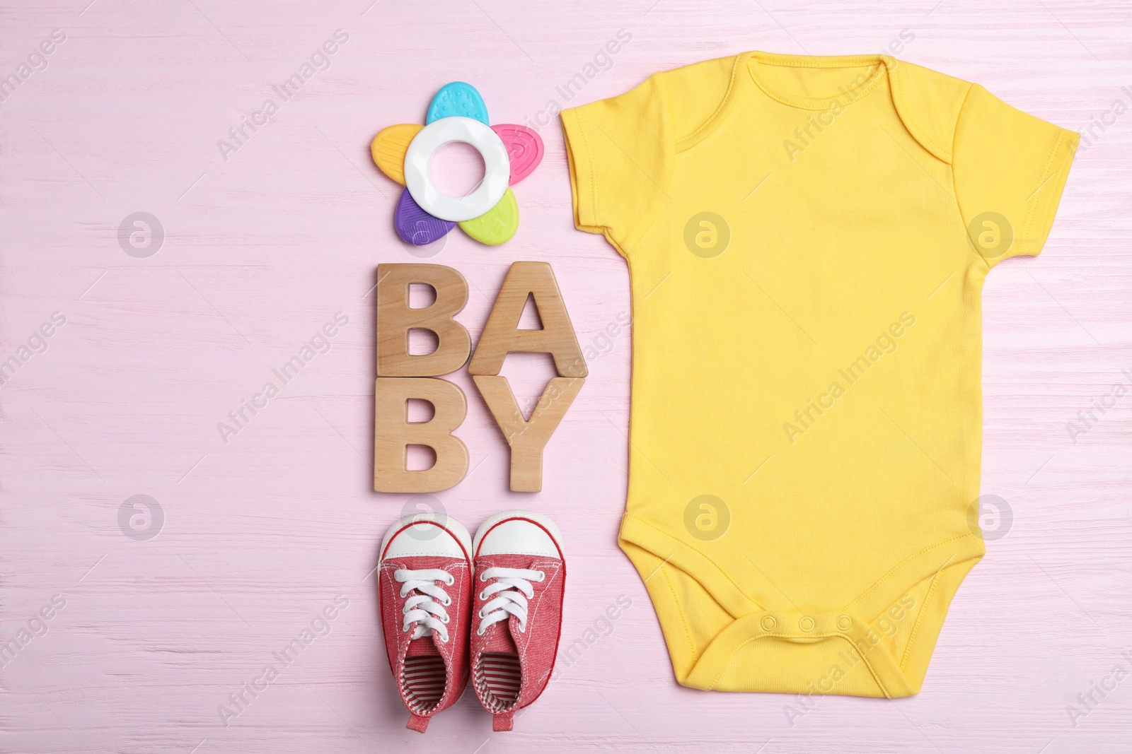 Photo of Flat lay composition with child's clothes on pink wooden table
