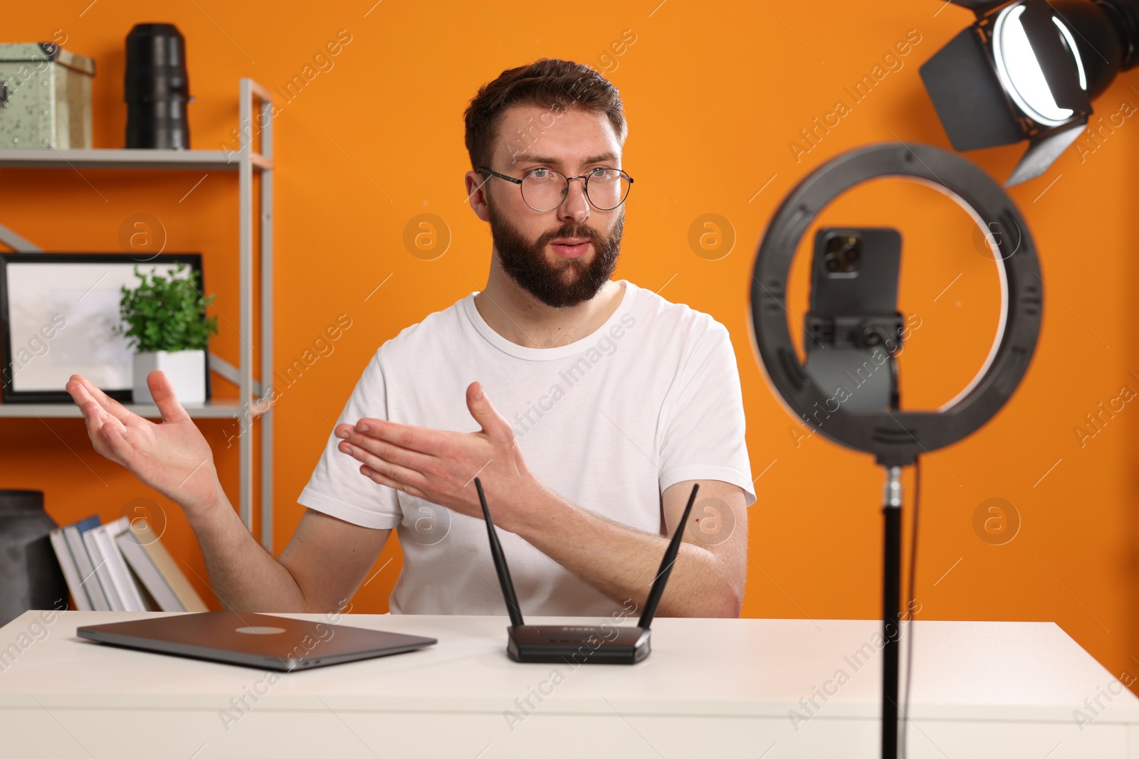 Photo of Technology blogger explaining something while recording video at home