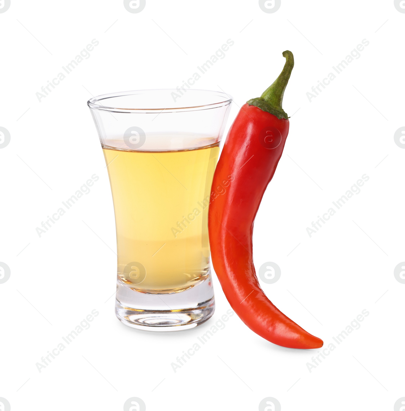 Photo of Red hot chili pepper and vodka in shot glass on white background