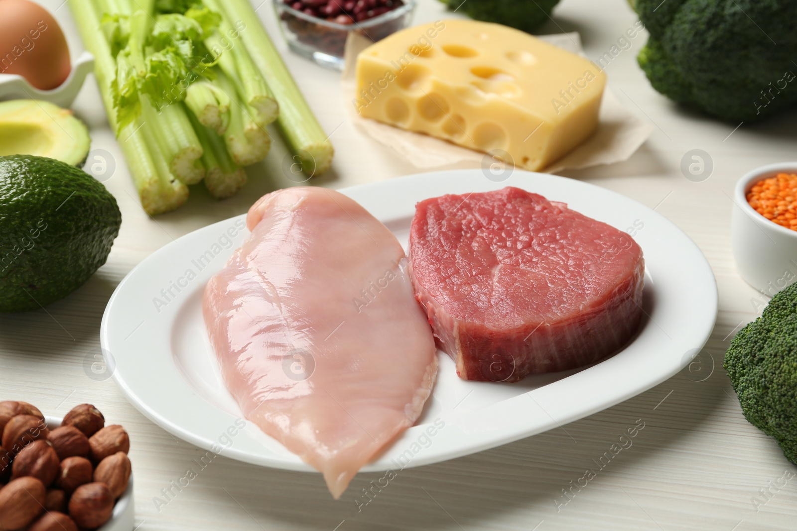 Photo of Fresh meat and other products on white wooden table. Sources of essential amino acids