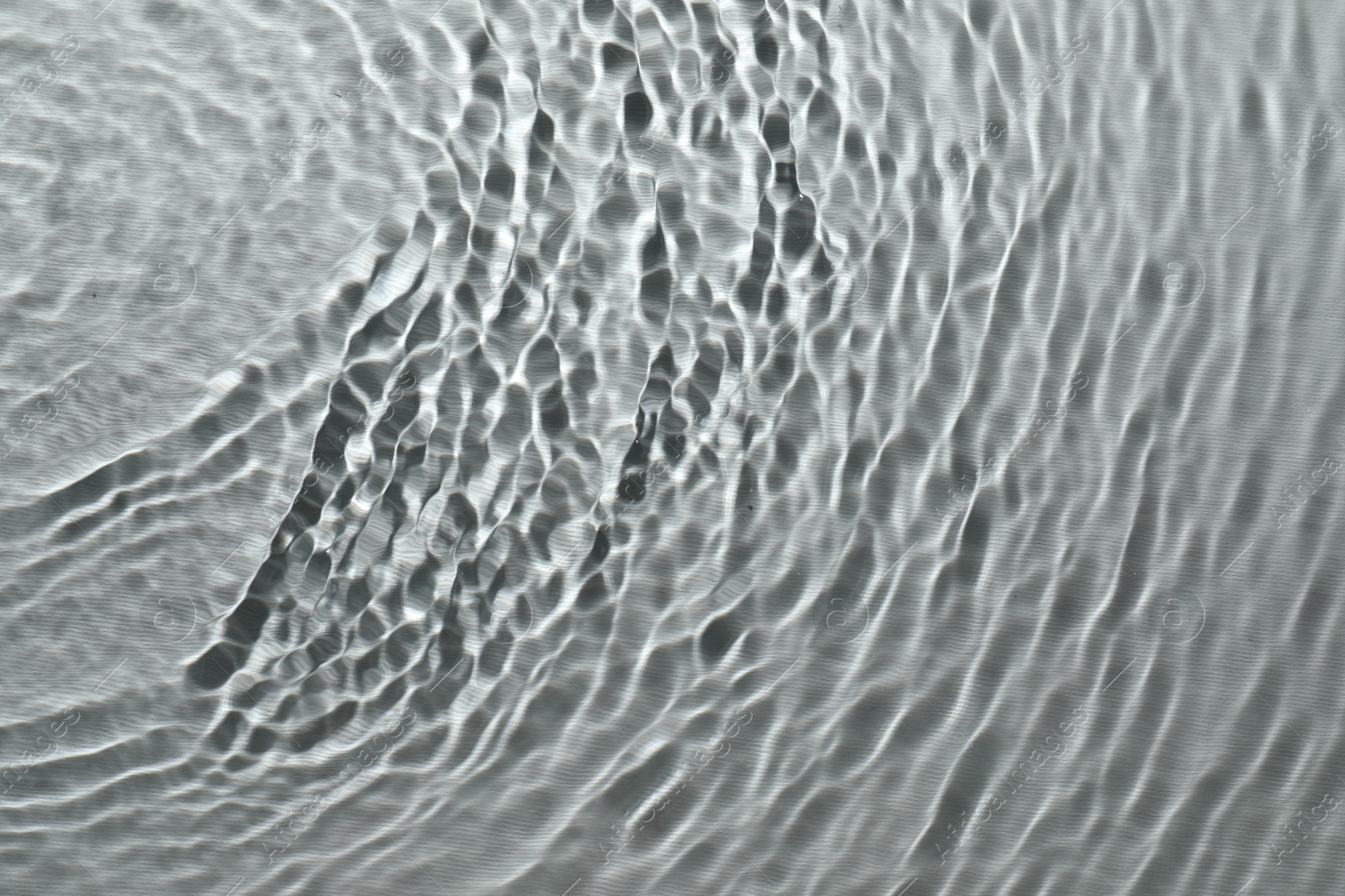 Photo of Rippled surface of clear water on light grey background, top view