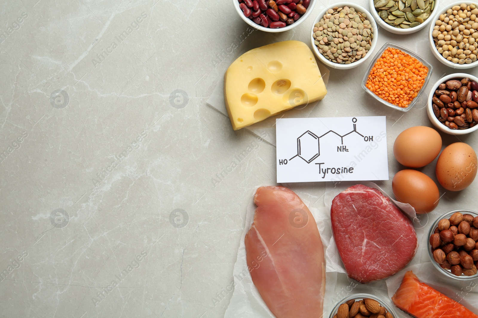 Photo of Set of products rich in amino acids and paper with Tyrosine chemical formula on light grey table, flat lay. Space for text
