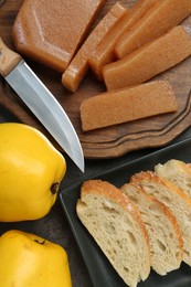 Photo of Delicious quince paste, bread, butter and fresh fruits on grey table, flat lay