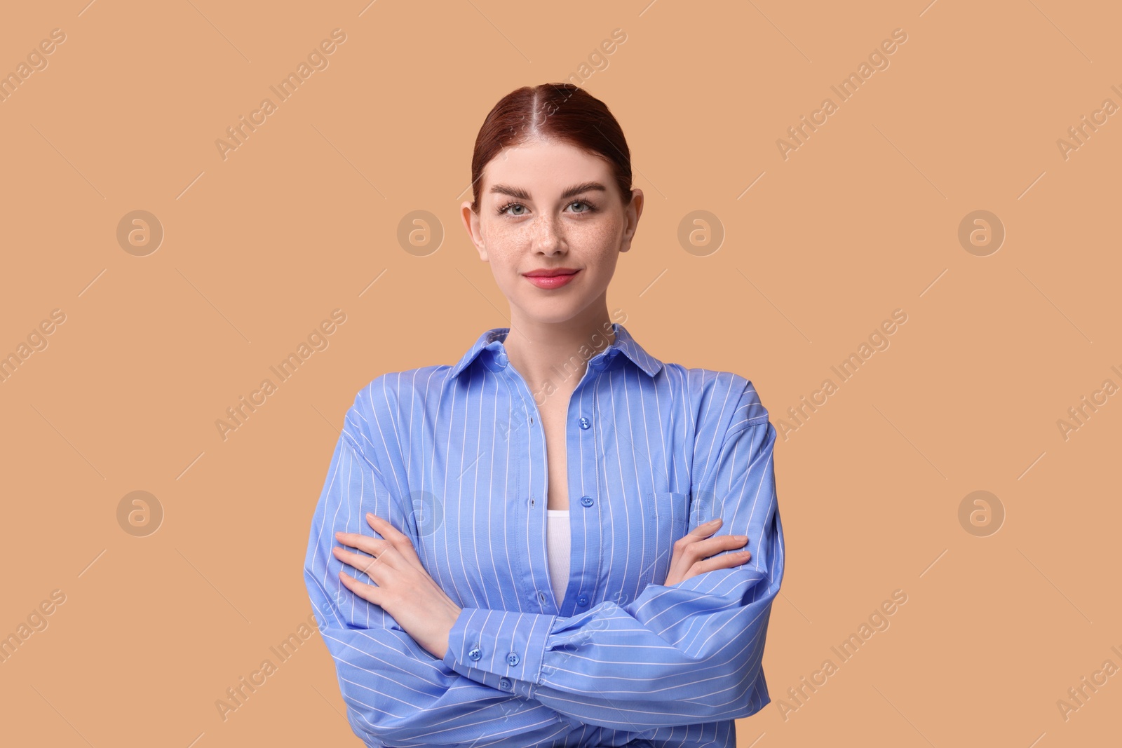 Photo of Portrait of beautiful woman with crossed arms on beige background