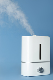 Modern air humidifier on light blue background