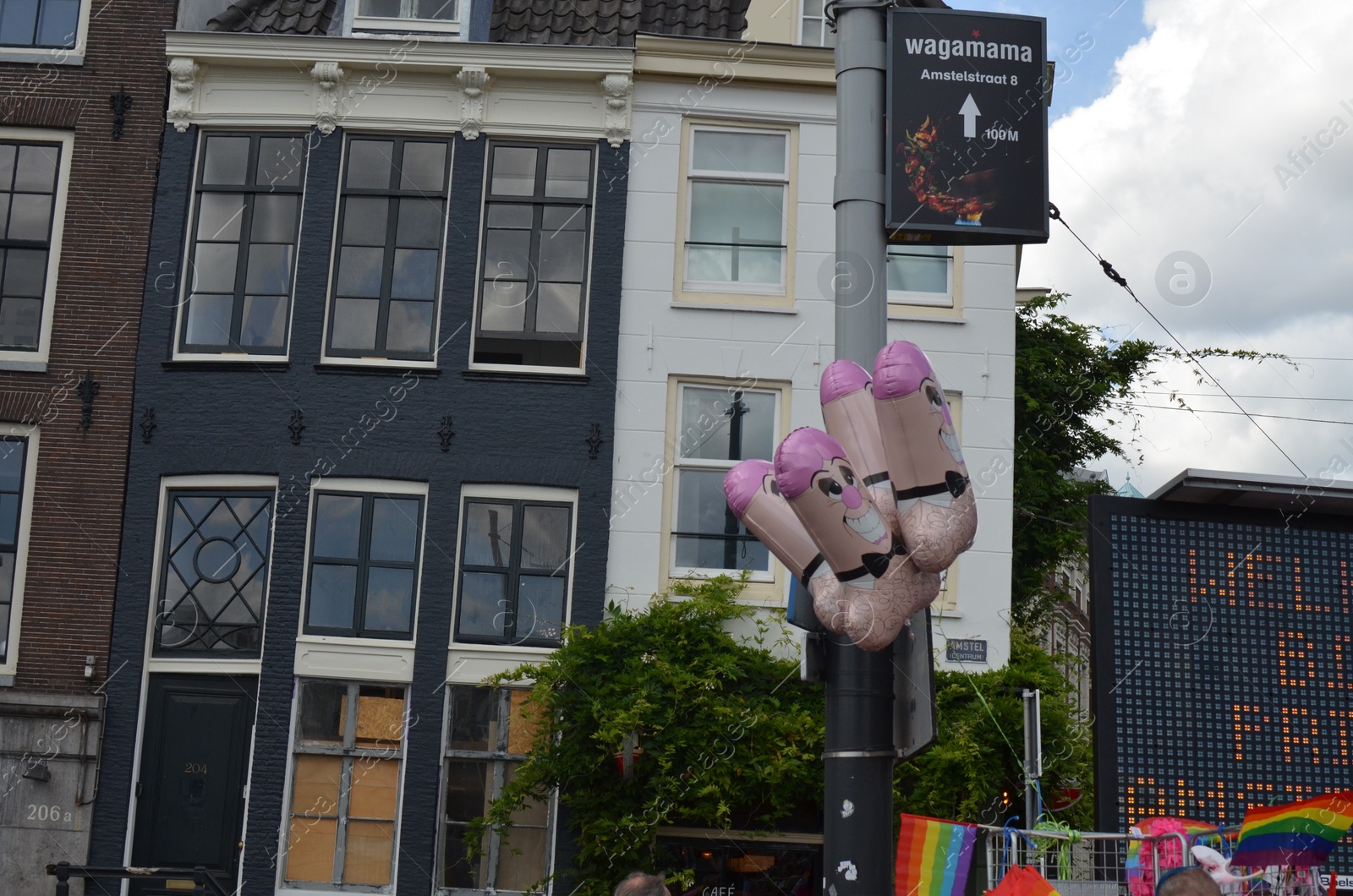 Photo of AMSTERDAM, NETHERLANDS - AUGUST 06, 2022: Male sexual organ shaped balloons at LGBT pride parade on city street