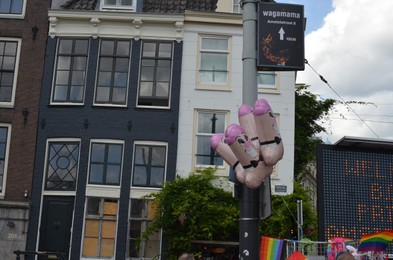 AMSTERDAM, NETHERLANDS - AUGUST 06, 2022: Male sexual organ shaped balloons at LGBT pride parade on city street
