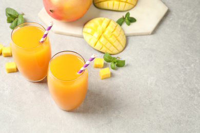 Fresh delicious mango drink on light table. Space for text