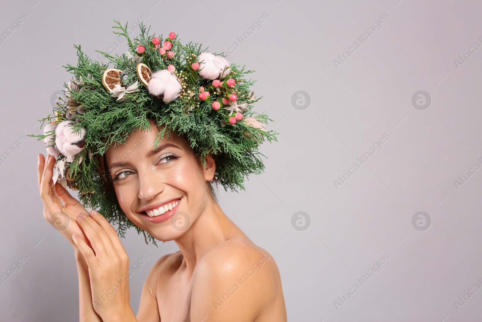 Photo of Happy young woman wearing wreath on grey background. Space for text