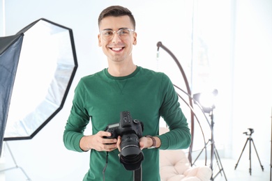 Photo of Young photographer with professional camera in studio
