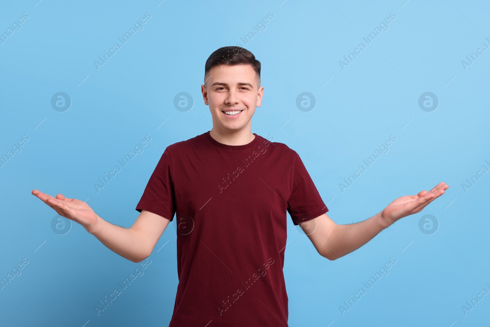 Photo of Handsome man inviting to come in against light blue background