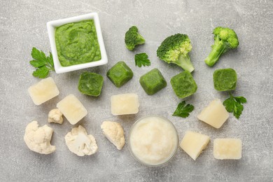 Frozen cauliflower and broccoli puree cubes with ingredients on light grey table, flat lay