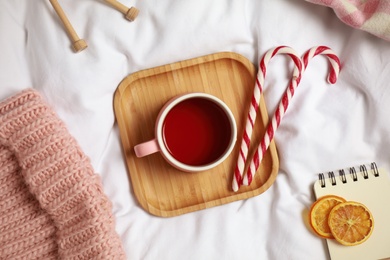 Photo of Flat lay composition with cup of hot winter drink on light fabric