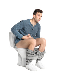 Photo of Man suffering from stomach ache on toilet bowl, white background