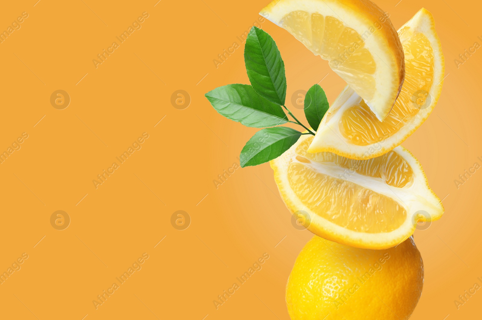 Image of Cut and whole fresh lemons with green leaves falling on orange background, space for text
