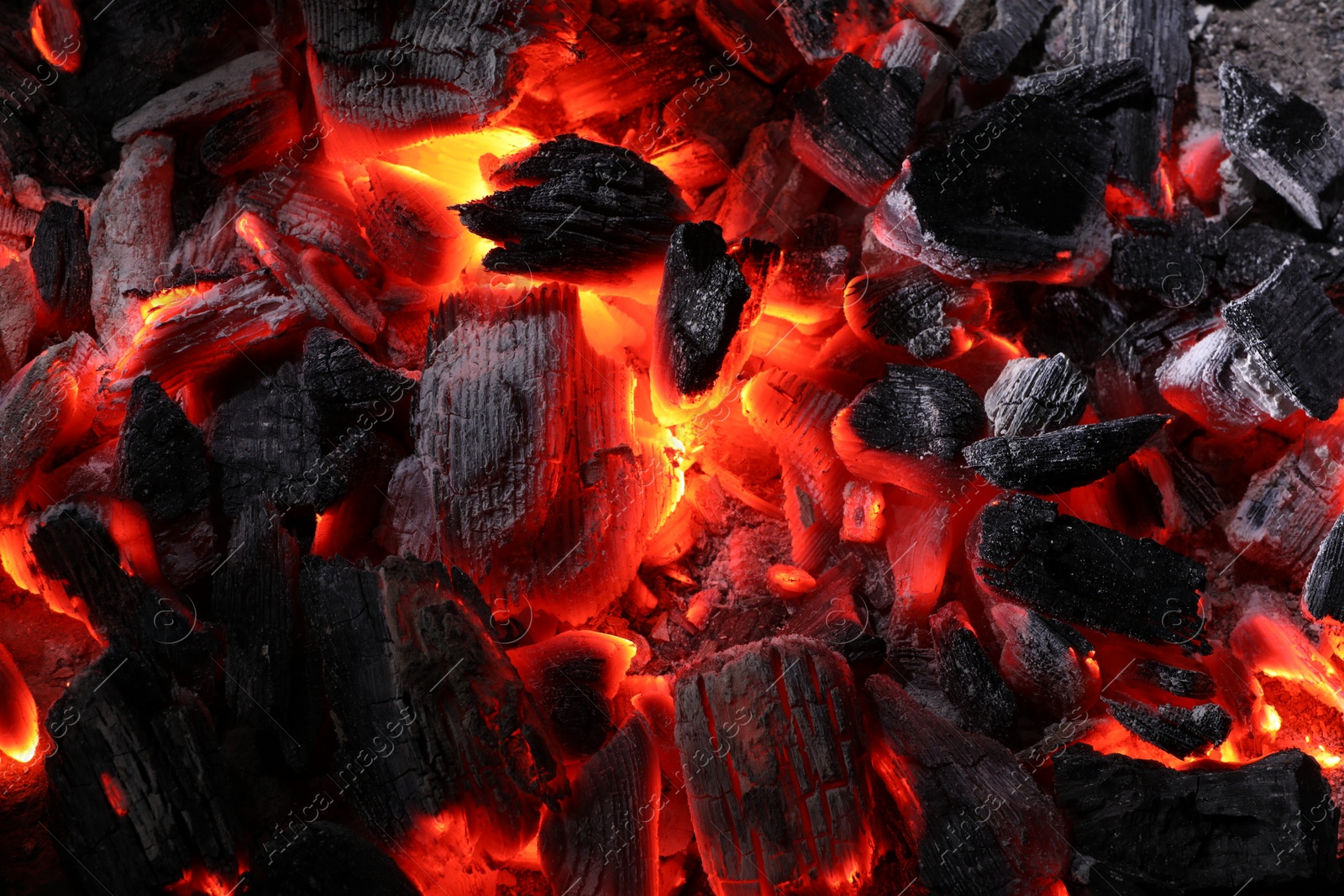 Photo of Pieces of hot smoldering coal as background, top view