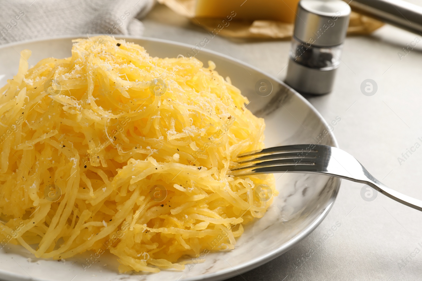 Photo of Plate with cooked spaghetti squash on gray table