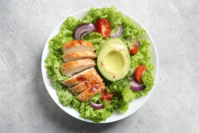 Photo of Delicious salad with chicken, avocado and vegetables on light grey table, top view