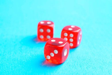 Three red game dices on light blue background, closeup. Space for text