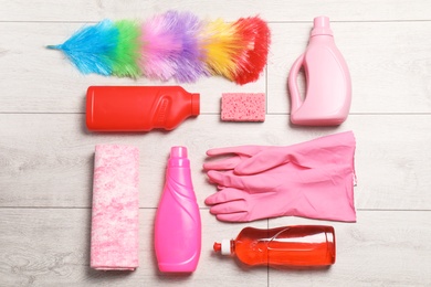 Flat lay composition with cleaning supplies on wooden background