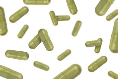 Image of Vitamin. Many capsules falling on white background