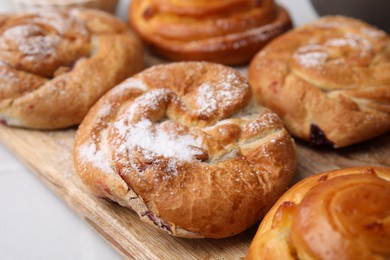 Delicious rolls with powdered sugar on table, closeup. Sweet buns