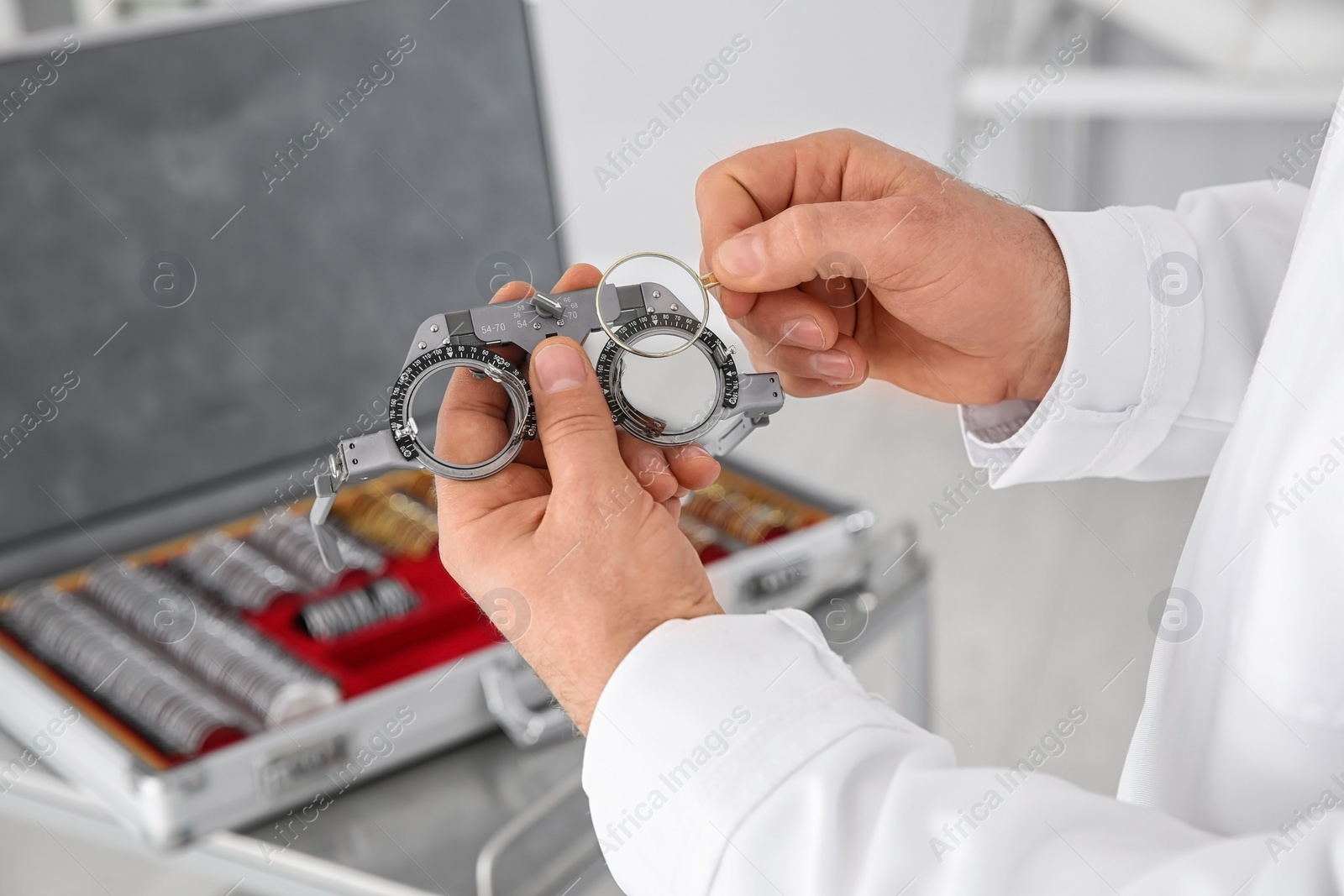 Photo of Children doctor holding trial frame and lens on blurred background, closeup