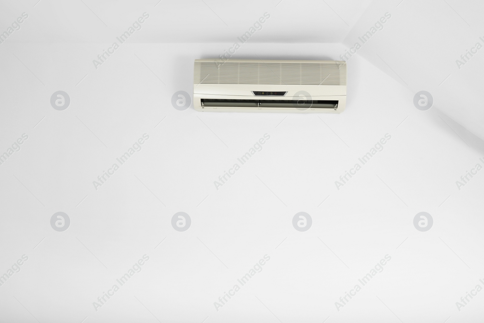 Photo of Modern air conditioner on white wall indoors