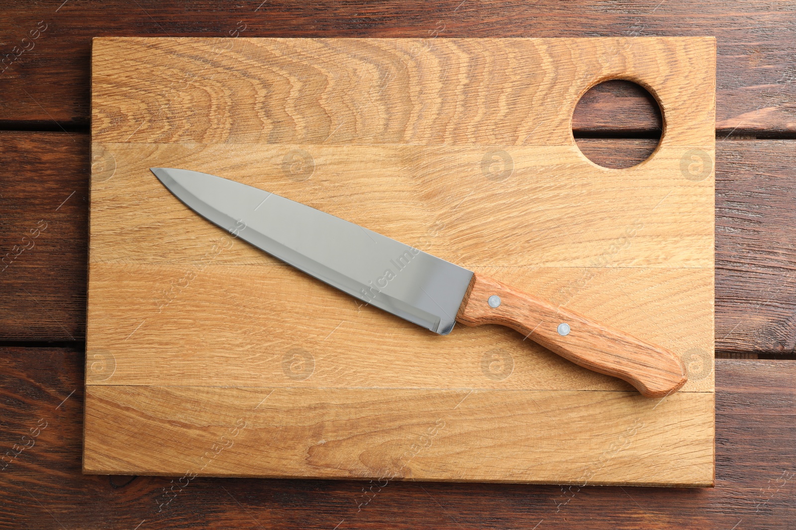 Photo of One sharp knife and board on wooden table, top view