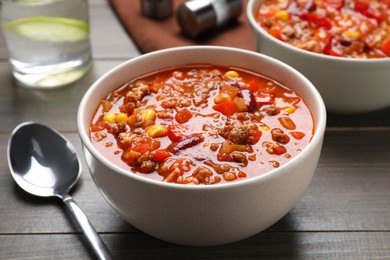 Photo of Tasty chili con carne served on wooden table, closeup