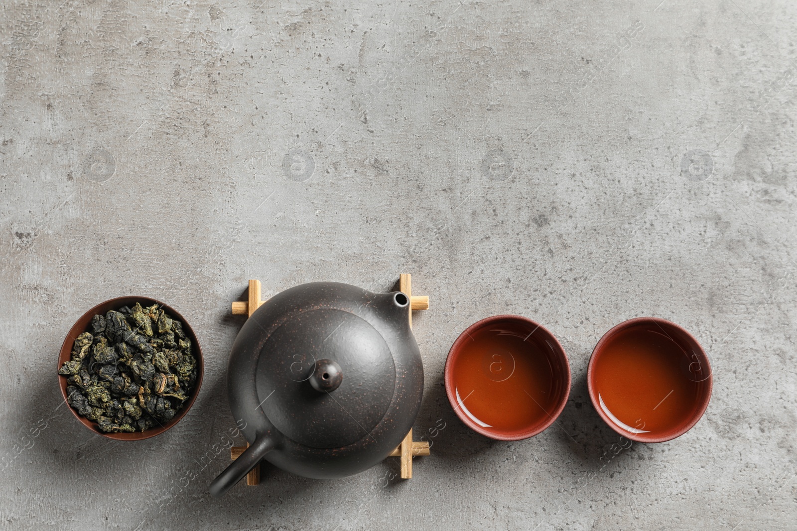Photo of Flat lay composition with cups of Tie Guan Yin oolong tea and space for text on grey background