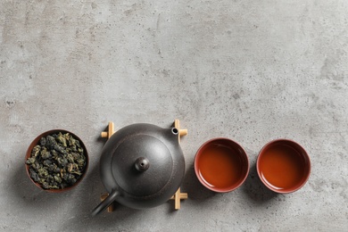 Flat lay composition with cups of Tie Guan Yin oolong tea and space for text on grey background