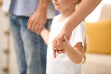 Photo of Happy family holding hands indoors, closeup view