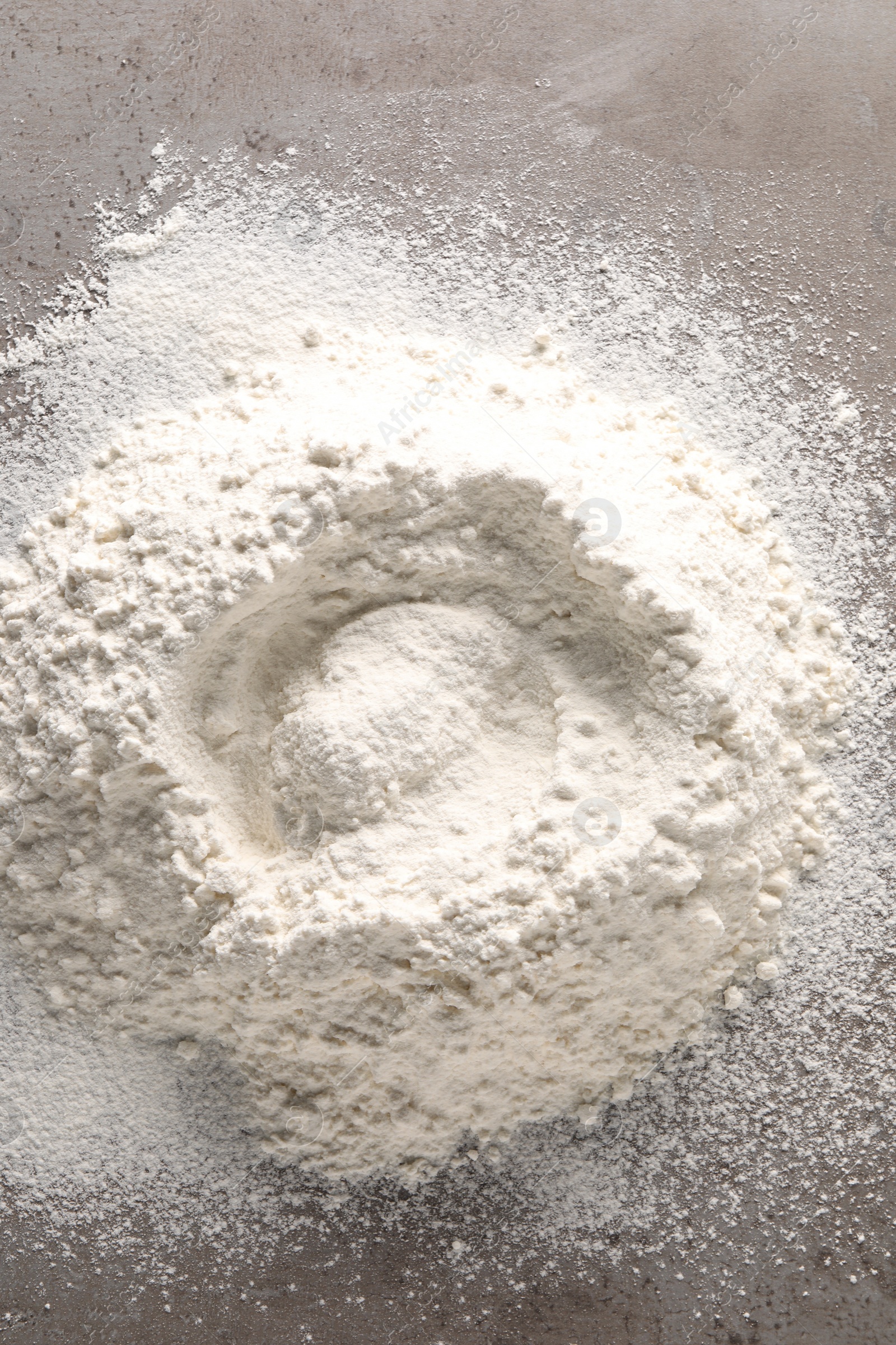 Photo of Pile of flour on grey textured table, top view