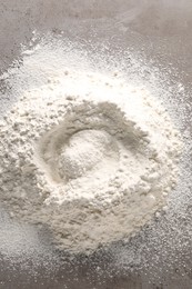 Photo of Pile of flour on grey textured table, top view