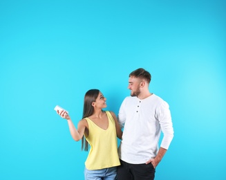 Photo of Young couple with air conditioner remote on color background