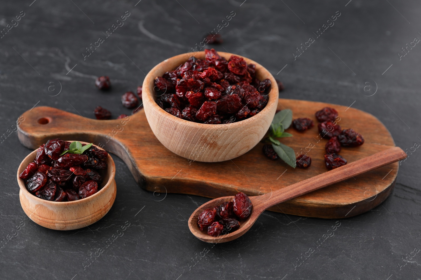 Photo of Composition with tasty dried cranberries on black table