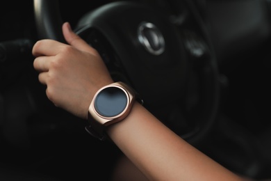Young woman with smart watch in car, closeup