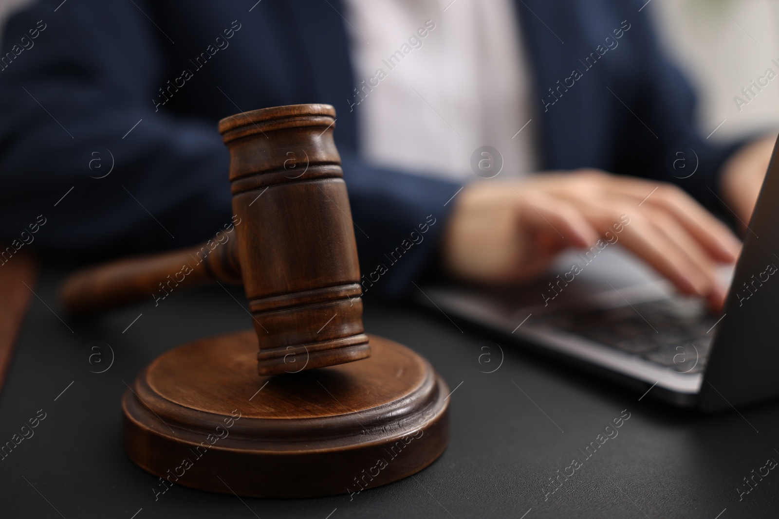 Photo of Notary working with laptop at table, focus on gavel