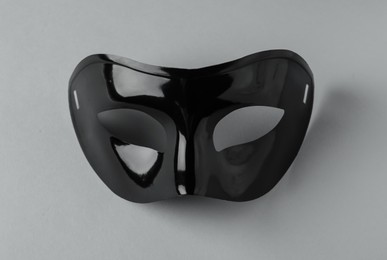 Photo of Black theatre mask on grey background, above view