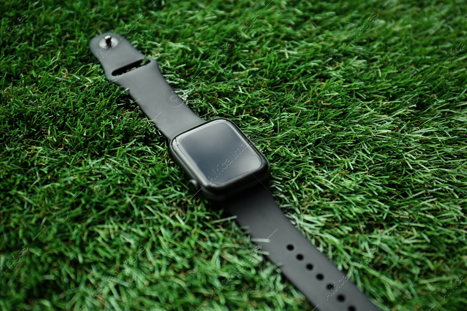 Modern stylish smart watch on green grass, closeup Photo of Modern stylish smart watch on green grass, closeup
