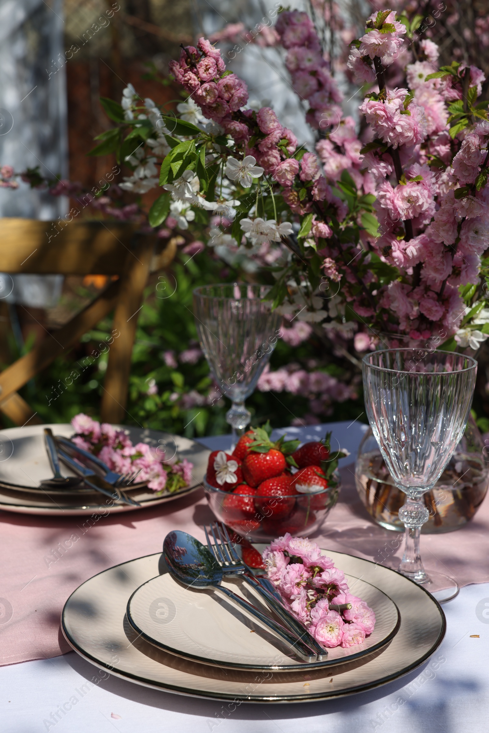 Photo of Stylish table setting with beautiful spring flowers in garden