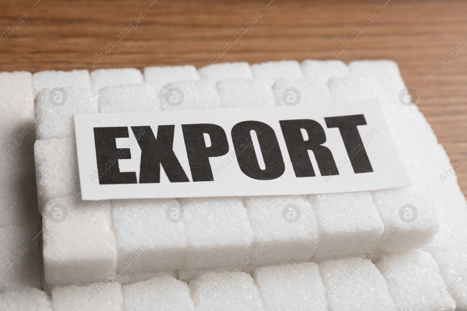 Photo of Card with word Export and many sugar cubes on wooden table, closeup