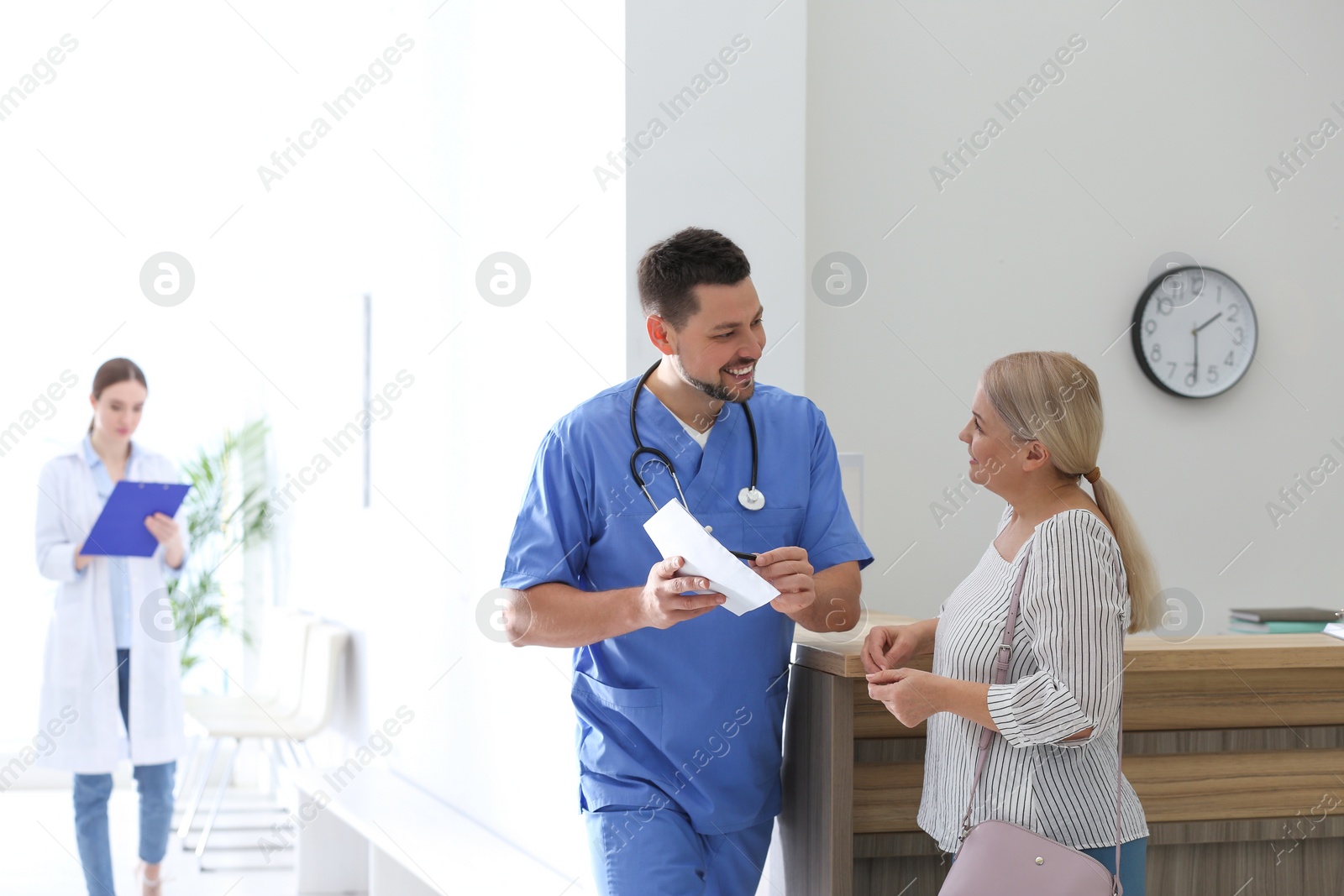 Photo of Doctor talking with patient in hospital hall